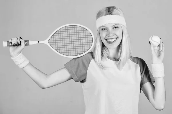 アクティブなレジャーと趣味。テニススポーツとエンターテイメント。テニスクラブのコンセプト。女の子愛らしいブロンドはテニスをプレイ。健康を維持するためのスポーツ。アスリートは灰色の背景に手にテニスラケットを保持します — ストック写真
