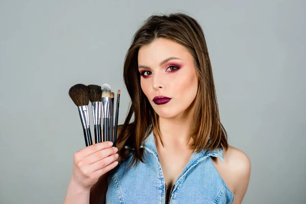 La fille applique des ombres à paupières. Femme appliquant une brosse de maquillage. Insistez sur la féminité. Fournitures de maquillage professionnel. Soins de la peau. Différentes brosses. Concept cosmétique maquillage. Correcteur de teint. Magasin de cosmétiques — Photo