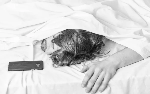 El primer plano de los pies en la cama bajo la manta blanca. Imagen que muestra a un joven estirándose en la cama. Relajante por la mañana . — Foto de Stock