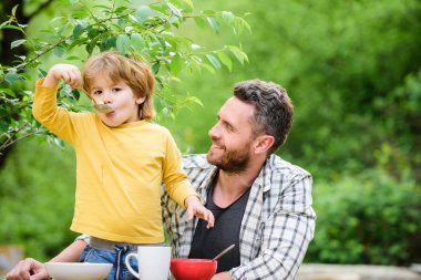 Aile akşam yemeği zamanı. mutlu babalar günü. Babası olan küçük çocuk tahıl yiyor. Yaz piknik. Sabah kahvaltısı. sağlıklı gıda ve diyet. Çocuk günü. Baba ve oğlu açık yeme. Mutlu aile konsepti