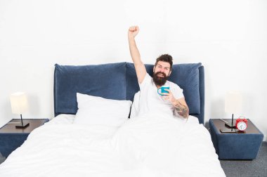 Adam acımasız yakışıklı hipster rahatlatıcı yatak odası içecek kahve. Sakallı adam sabah kahvesini hoşuna giderdi. Yeni güne ayarlayın. Günaydın, fincan kahvesi ile daha iyi uyanma. Rahatla ve dinlen. İnsanlık kahve üzerinde çalışır