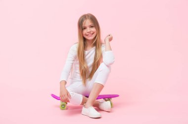 Penny tahtasında Vibes zevk. Pembe arka planda Penny Board güvertede oturan sevimli küçük çocuk. Violet Penny kurulu ile sevimli kız patenci. Penny kaykay ile küçük kaykaycı