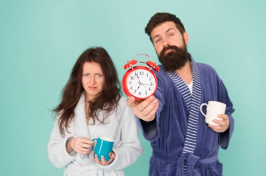 Kahve zamanı. Sakal ve uykulu kadın ile adam sabah kahve veya çay zevk. Banyo kıyafetleri içinde adam çay kahve tutun. Kahvaltı konsepti. Her sabah kahve ile başlar. Çift bornozlu kupalar