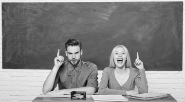 Adam ve kız sınıfta masada otur. Doğru cevap onların aklında. Kolej veya üniversite okuyor. Ücretsiz program uygulanır. Kaç arkadaş üniversite okuyan öğrenciler. Üniversite hayatının tadını çıkarıyor