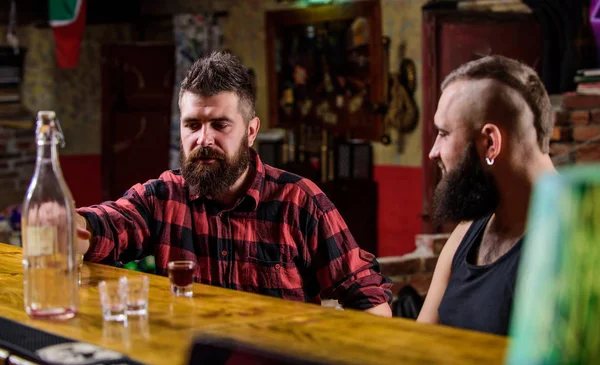 Bebidas alcohólicas fuertes. Viernes de relajación en el bar. Amigos relajándose en el bar o pub. Interesante conversación. Hipster hombre barbudo brutal pasar el ocio con un amigo en el mostrador del bar. Hombres relajándose en el bar — Foto de Stock