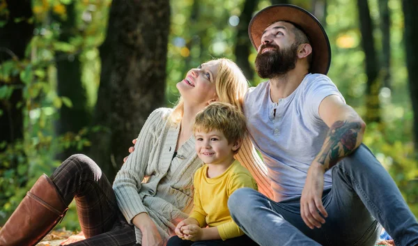 Conceito de dia de família. Família feliz com garoto relaxando enquanto caminhava na floresta. Fim de semana familiar. Mãe pai e filho pequeno sentar piquenique floresta. Bom dia para piquenique de primavera na natureza. Unidos com a natureza — Fotografia de Stock