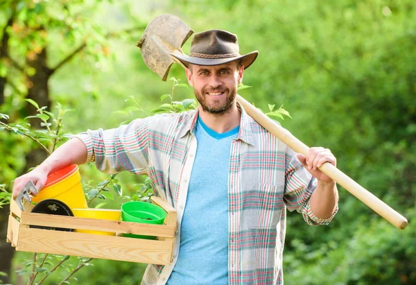 Agricultor sexy segurar pá e caixa com pote. Homem do rancho musculado de chapéu de cowboy. agricultura e agricultura. Equipamento de jardim. Eco fazenda. Colheita. Feliz Dia da Terra. Eco vida. Eu adoro trabalhar com flores — Fotografia de Stock