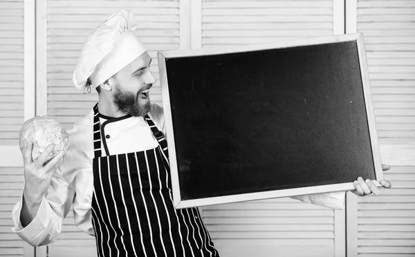 Man chef hat apron hold blackboard copy space. Recipe concept. Cooking delicious meal step by step. Menu for today. List ingredients for cooking dish. Check out cooking tips. Tips to cook like pro