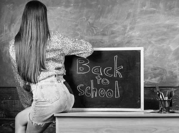 Kız kot etek okul giyim kuralları ihlal. Okul kıyafet. Kara tahta yakınındaki sırt ve kalça öğrenci. Öğrenci öğretmen mini etek seksi kalça tablo blackboard yazıt okula otur — Stok fotoğraf
