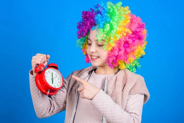 O seu tempo de descanso. Menina feliz com cabelo de peruca colorido apontando para o despertador para o tempo exato. Conceito de tempo. Praticar uma boa gestão do tempo — Fotografia de Stock