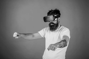 Sanal yarış kavramı. Sanal gerçeklik yüksek hızda sürüş bisiklet emin yüzündeki hippi. Vr sakallı sürüş motosiklet, kırmızı arka plan gözlük. Adam oyun Vr içinde yarış oyunu