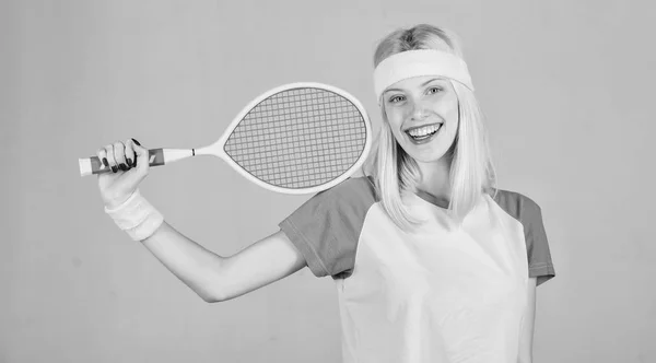 Concepto de club de tenis. Chica adorable rubia jugar al tenis. Deporte para mantener la salud. Ocio activo y hobby. El atleta sostiene la raqueta de tenis en la mano sobre fondo gris. Tenis deporte y entretenimiento — Foto de Stock