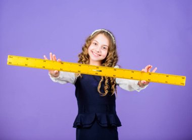 Çocuk okul üniforması hakim. Büyük cetvel ile Öğrenci sevimli kız. Geometri okulu konusu. Eğitim ve okul konsepti. Akıllı ve akıllı bir kavram. Boyutlandırma ve ölçme. Okul öğrenci çalışma geometrisi