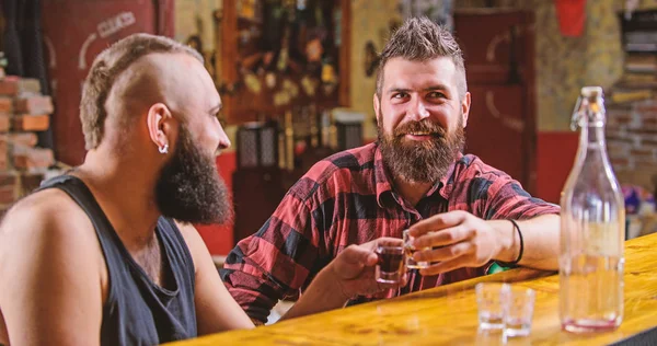 Men relaxing at bar. Strong alcohol drinks. Friday relaxation in bar. Friends relaxing in bar pub. Cheers concept. Lets get drunk. Hipster brutal bearded man spend leisure with friend at bar counter