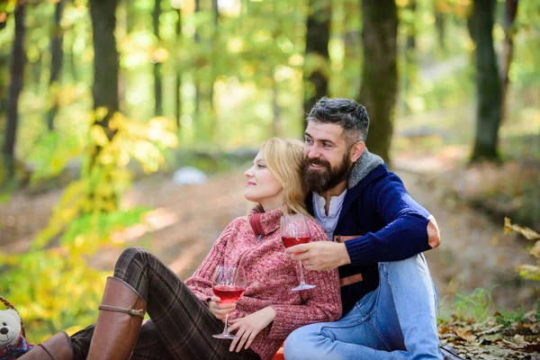 Par Gos dricka vin. Happy Loving par koppla av i parken tillsammans. Romantisk picknick med vin i skogen. Par i kärlek fira årsdagen picknick datum. Njuter av sitt perfekta datum — Stockfoto