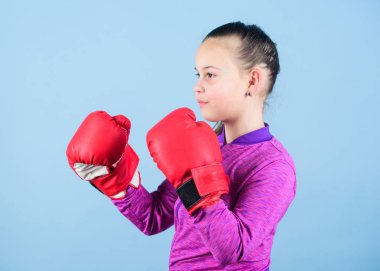 Mavi arka plan üzerinde kız sevimli boksör. Klişenin aksine. Boks eldivenli boksör çocuk. Kendine güvenen bir genç. Spordan zevk. Kadın boksör. Spor terbiyesi. Boks sıkı disiplin sağlar