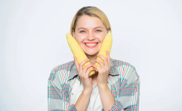 La comida trae felicidad. Mujer mantenga mazorca de maíz amarillo fondo blanco. Cosecha de maíz. La chica tiene maíz maduro. Alimentos vegetarianos y saludables productos orgánicos naturales. Menú vegetariano. Concepto de comida saludable —  Fotos de Stock