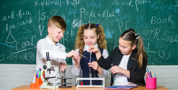 Ученики групповой школы изучают химию в школе. Мальчикам и девочкам нравится химический эксперимент. Органическая химия изучает соединения, содержащие углерод. Основные химические реакции. Захватывающая химия — стоковое фото