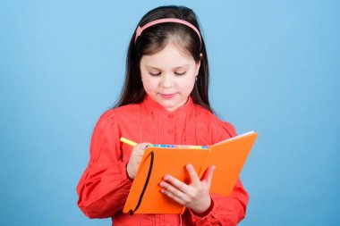 Çocuk kitap yazıyor. Kitap konsepti. Gelişim ve eğitim. Ev ödevi egzersizi. Kompozisyon yazın. Edebiyat kulübü. Kişisel günlük. Çalış ve öğren. Şiir yazarı. Kız kitap mavi arka plan tutun