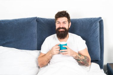 Rahatla ve dinlen. İnsanlık kahveyle çalışır. Adam acımasız yakışıklı hipster rahatlatıcı yatak odası içki kahve. Sakallı adam sabah kahvesi içiyor. Yeni güne uyum içinde. Sabah fincan kahve ile daha iyi uyanma