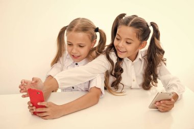 Okul sonu akıllı telefonlar kullanarak mutlu küçük kızlar için. küçük kızlar eğleniyor okul tatilinde akıllı telefonlar kullanarak.