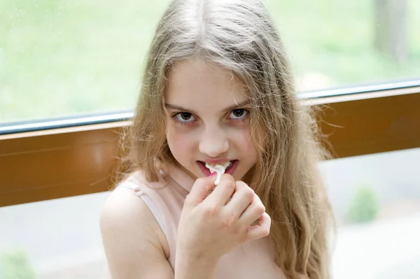 Kauwgom te blijven gevoelb. Schattig klein meisje kauwen een gum. Schattig klein kind stretching witte kauwgom. Bescherming van de tanden gezondheid met kauwgom — Stockfoto