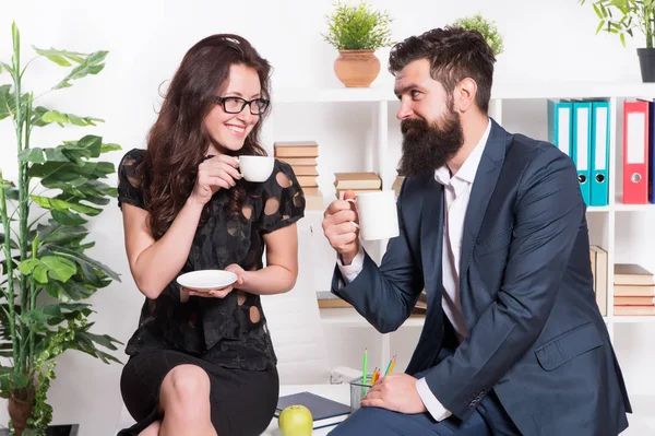Office rumors. Couple coworkers relax coffee break. Share coffee with with colleague. Flirting colleagues. Bearded man and attractive woman. Man and woman conversation coffee time. Office coffee