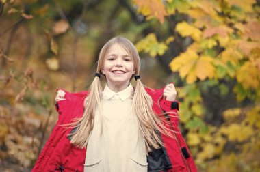 Sıcak ceket açık yürüyüş çocuk sarı uzun saçlı. Kız kırmızı ceket mutlu sonbahar park iyi hava keyfini çıkarın. Çocuk giyim moda ceket. Giyim Sonbahar ve kavram moda. Rahat ve kaygısız