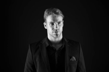 Adam yakışıklı bakımlı maço siyah arka plan üzerine. Duygu kendinden emin. Erkek güzellik ve erkeklik. Adam çekici emin modeli. Onun tarzı kendine güvenen. Karanlık giysili adam. Raslantı yakışıklı