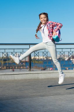 Dışarıda aktif olmak. Kentsel altyapıda hareketli küçük bir çocuk. Zevk için atlayan mutlu küçük kız. Aktif ve enerjik bir çocuk yazın eğleniyor.