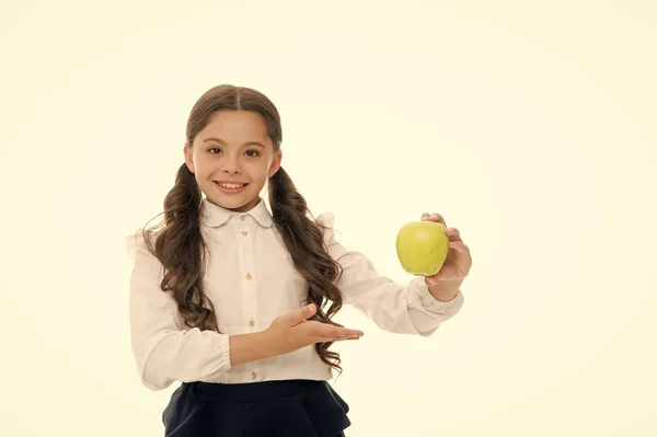 Menina bonito cabelo encaracolado longo mantém maçã fruta fundo branco. Criança estudante segura maçã. Criança criança cara feliz como maçã. Conceito de lanche escolar. Dieta nutricional saudável. Maçã vitamina lanche — Fotografia de Stock