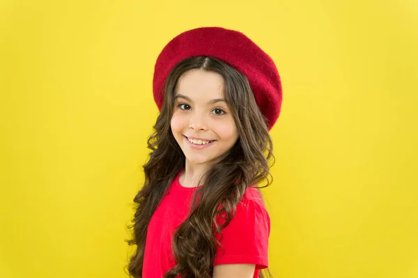 Moderne mode stijl. kindertijd. kapsalon. Een klein meisje met een Franse hoed. Zomer mode en schoonheid. Parijse kind op gele achtergrond. gelukkig meisje met lang krullend haar in baret — Stockfoto