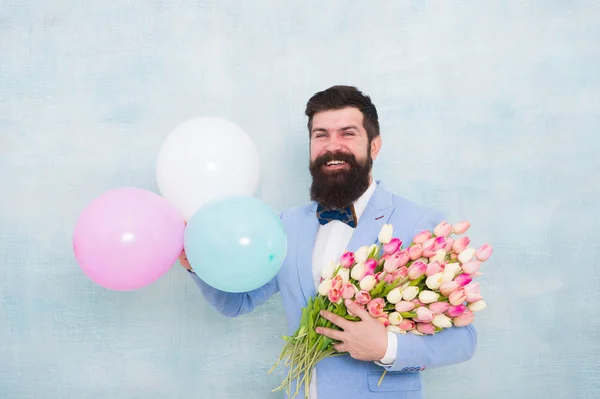 Gentleman romantic date. Birthday greetings. Flowers delivery. For someone special. Man bearded gentleman suit bow tie hold air balloons and bouquet. Gentleman making romantic surprise for her