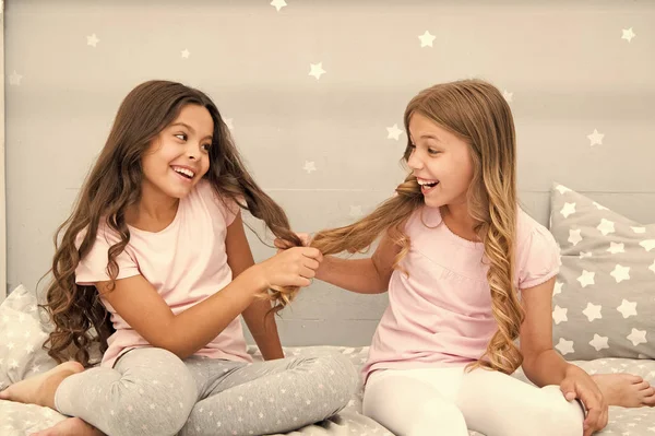 Niños alegre juego con el pelo en el dormitorio. Felices momentos de infancia. Niños niñas hermanas mejores amigos llenos de energía en estado de ánimo alegre. Crecer el cabello fuerte y saludable. Concepto de cuidado del cabello. Cabello fuerte —  Fotos de Stock