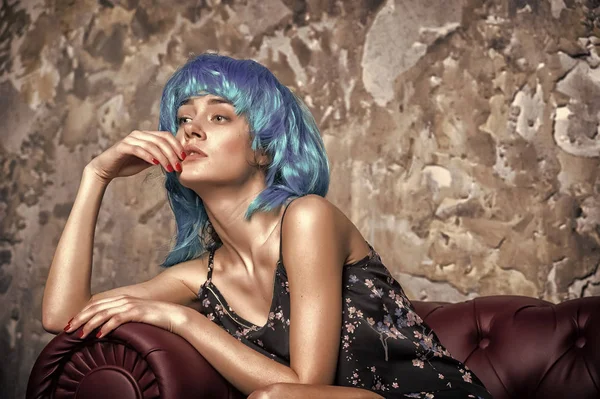 Senhora na cara pensativa posando em peruca azul, fundo de parede de concreto. Mulher com cabelo azul parece estranho e extraordinário. Conceito estranho. Senhora aberração com aparência incomum — Fotografia de Stock