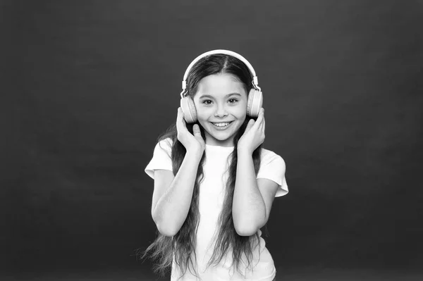 La música sabe. La música juega un papel importante vidas adolescentes. Efecto poderoso música adolescentes sus emociones, percepción del mundo. Chica escuchar auriculares de música en el fondo rojo. Concepto de lista de reproducción — Foto de Stock