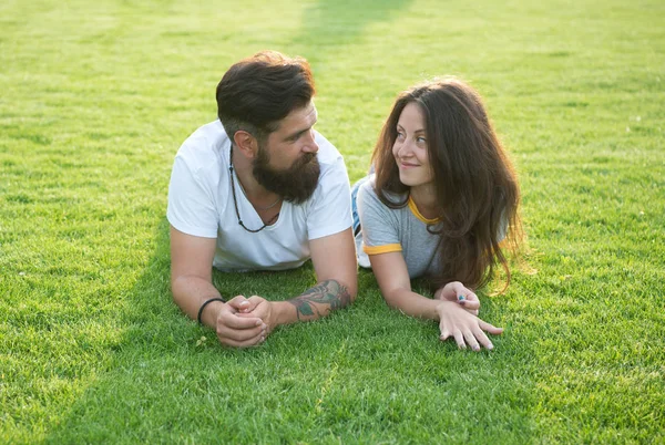 Relajado y enamorado. Pareja relajándose en la hierba disfrutando el uno del otro. Hombre barbudo hipster y hermosa mujer enamorada. Vacaciones de verano. Enamórate. Felicidad veraniega. Felices juntos. Pareja enamorada —  Fotos de Stock