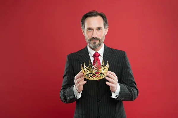 It is his proud boast. Source of pride. Proud businessman holding crown jewel with pride on red background. Mature man feeling great pride. Pride concept