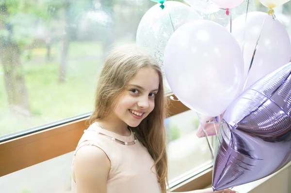 Wishing a happy holiday. Happy small child enjoying her birthday holiday. Adorable little girl celebrating holiday with party balloons. Joy and cheer, its a holiday party to celebrate special day