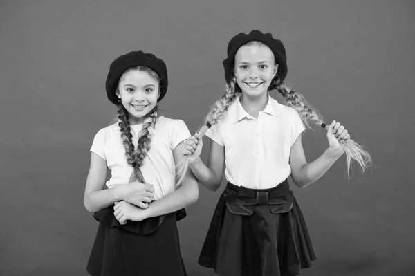 Lindo y elegante. Niños pequeños con elegantes boinas francesas. Chicas de estilo francés. Chicas lindas que tienen el mismo peinado. Niños pequeños con trenzas de pelo largo. Chicas de moda con el pelo atado en trenzas — Foto de Stock