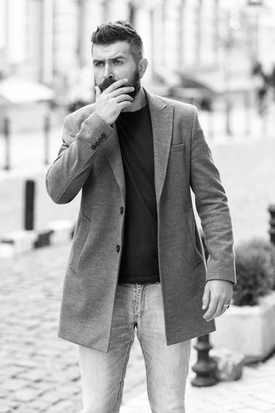 Businessman catching taxi while standing outdoors urban background. Man bearded hipster casual style waiting for taxi. Guy at street city center. Looking for transportation. Bus stop. Taxi please