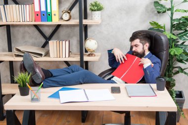 Finansal rapor. Adam bankacı muhasebeci işaretleri öğreniyor. Finansal rapor analiz ediliyor. Küçük işletmenin sahibi. Sakallı iş adamı ofisi iş raporlarını okuyor. Muhasebe ve bankacılık