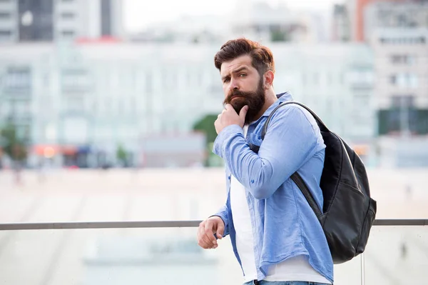 Turista bonito hipster com mochila stand street. Homem com barba e mochila explorar a cidade. Viagens e aventuras conceito. Turista em férias. Hipster moderno turista fundo urbano — Fotografia de Stock