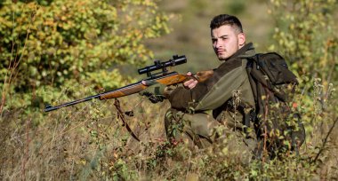 Avlanmak acımasız erkeksi bir hobidir. Hunter tüfeği tutuyor. Adam kamuflaj giysileri doğa arka plan giymek. Avlanma izni. Sakallı ciddi avcı boş zamanlarını avlayarak geçiriyor. Profesyoneller için av ekipmanları