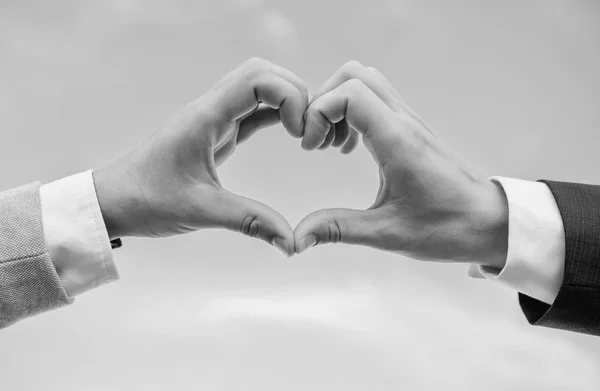 Love symbol concept. Hands put together in heart shape blue sky background. Male hands in heart shape gesture symbol of love and romance. Hand heart gesture forms shape using fingers