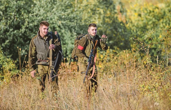 Hunting with friends. Hunters friends enjoy leisure. Hunters with rifles in nature environment. Teamwork and support. Activity for real men concept. Hunters gamekeepers looking for animal or bird