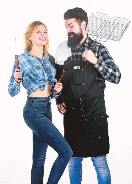 Picknick en barbecue. Man bebaarde hipster en meisje klaar voor barbecue partij. Culinair concept. Familieweekend. Paar in de liefde te houden kookgerei voor barbecue. Gereedschap voor het braden van vlees buitenshuis — Stockfoto