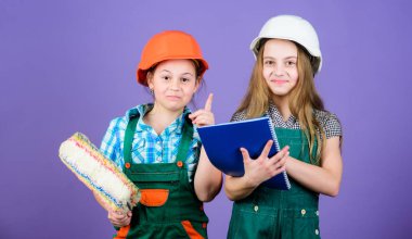 Tablet ve rulo ile kask küçük çocuklar. küçük kızlar atölyede birlikte tamir. mühendislik fikri. İşçi bayramı. 1 mayıs. Foreman müfettişi. Onarım. yaratılış için ilham kaynağı. Ilham