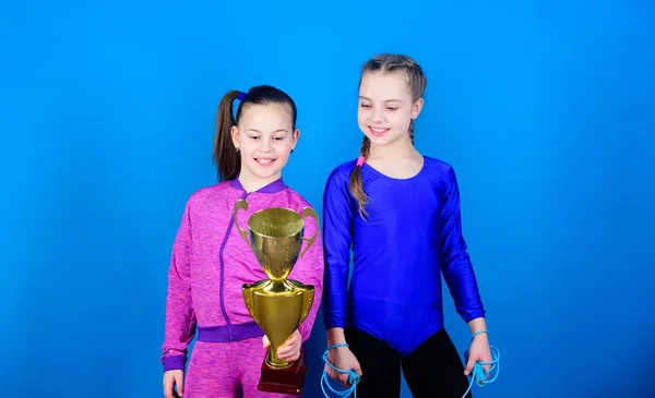 Sport success. victory of teen girls. Winners in competition. Acrobatics and gymnastics. Little girls hold jump rope. Happy children with gold champion cup. victory sport. victory celebration