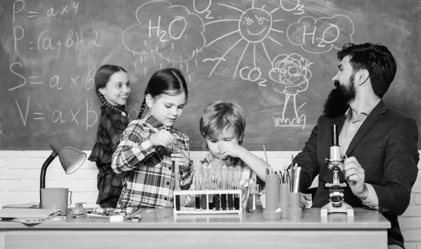 Η επιστήμη είναι πάντα η λύση. Παρατηρήστε την αντίδραση. Πείραμα χημείας του σχολείου. Συναρπαστικό μάθημα χημείας. Άντρας με γένια και μαθητές με δοκιμαστικούς σωλήνες στην τάξη. Εξηγώντας χημεία στα παιδιά — Φωτογραφία Αρχείου